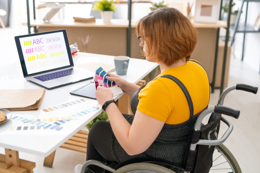 Website designer sits at her laptop working on website content. 