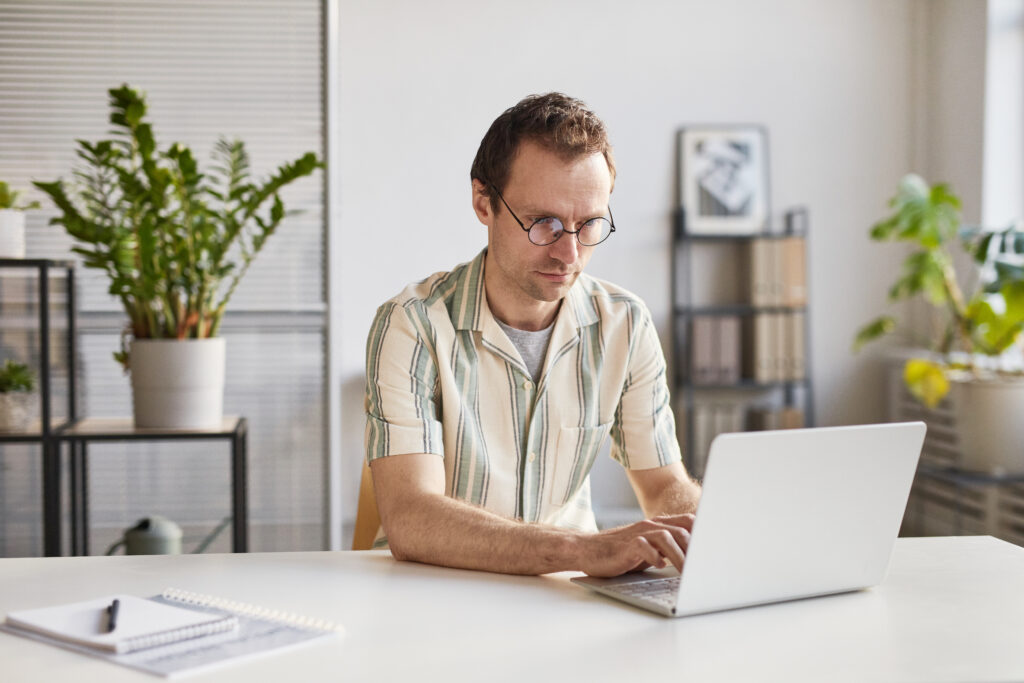 Man typing at laptop creates an email marketing strategy