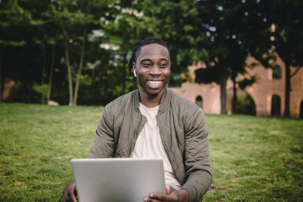 African American male in casual clothes with wireless earbuds listening to podcast