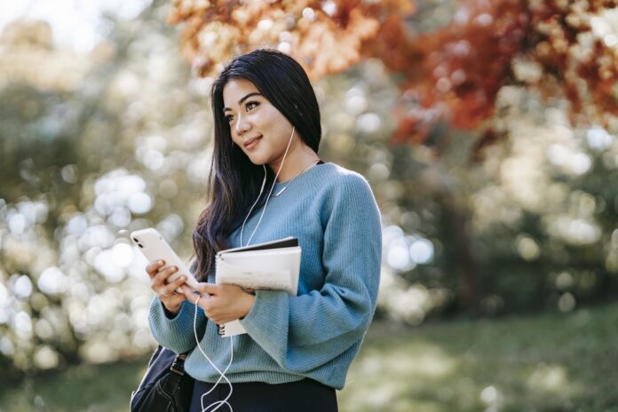 Young woman listing to a bible podcast using smartphone