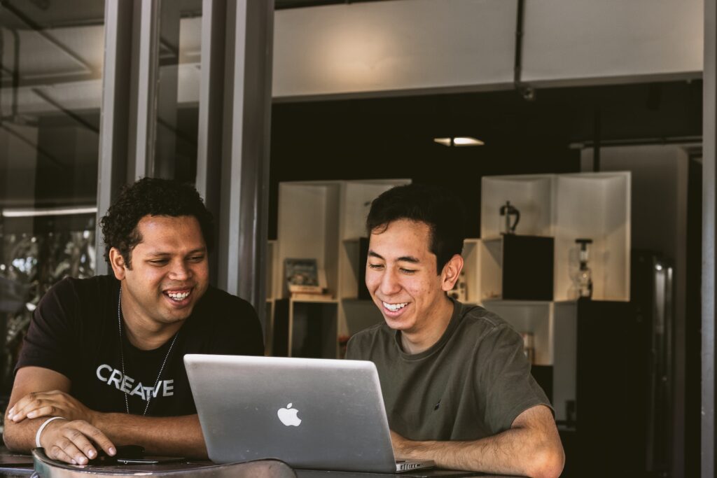 two smiling men working on church webpages