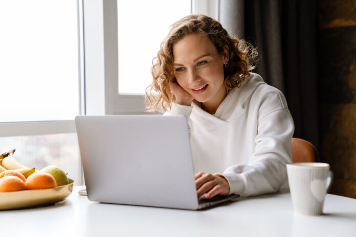 Woman working on a laptop, setting up church communication sequences.