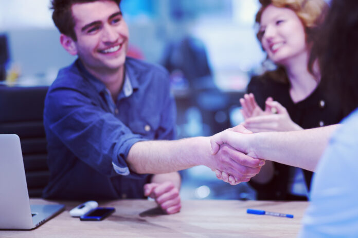 Two leaders shake hands, discussing how AI is helping churches thrive in today’s world.