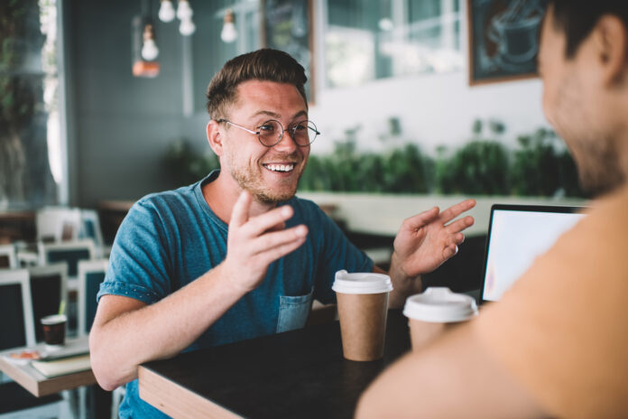 Two men in a coffee shop discuss the role of AI in ministry and its impact on church leadership.