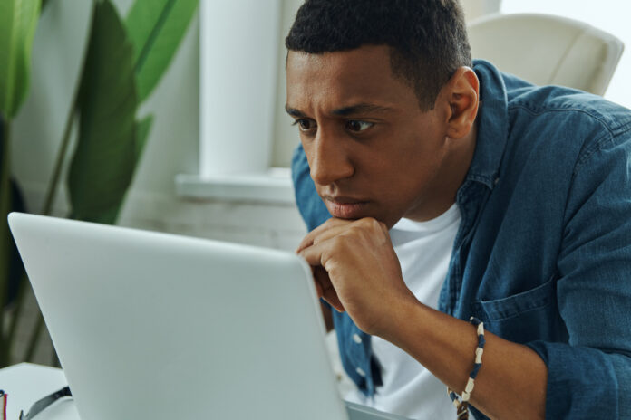 Man focused on laptop concerned about a Business Email Compromise.
